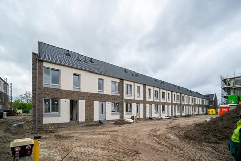 De voorgevel van een duurzame woning met een prefab dak en prefab schoorsteen.