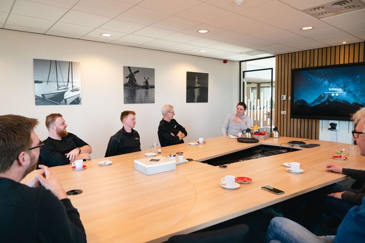 Collega's van Emergo Prefab zitten rond een tafel aan het overleggen