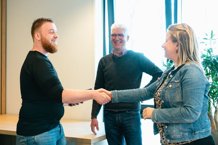 Student schudt de hand van opleider van ROC van Twente en neemt diploma in ontvangst